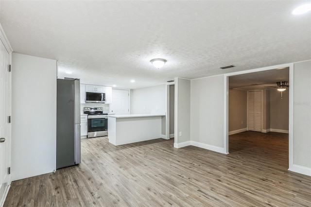 kitchen featuring white cabinetry, ceiling fan, light hardwood / wood-style flooring, a textured ceiling, and appliances with stainless steel finishes