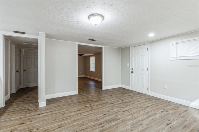 unfurnished room featuring wood-type flooring and a textured ceiling