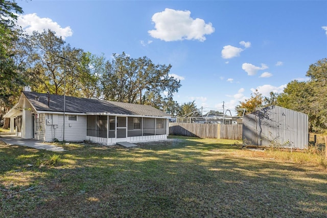 back of property featuring a lawn and a sunroom