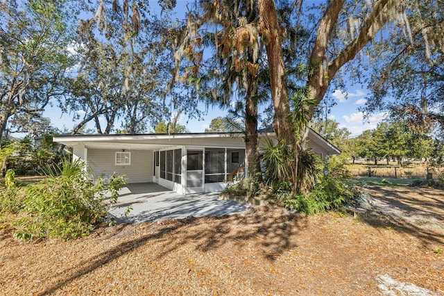 rear view of property with a sunroom and a patio