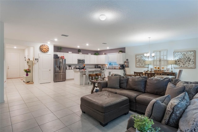 living room featuring a chandelier and light tile patterned flooring