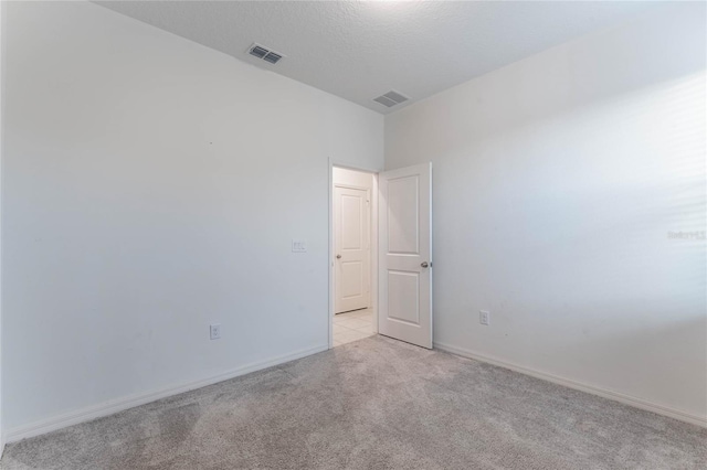 carpeted empty room with a textured ceiling