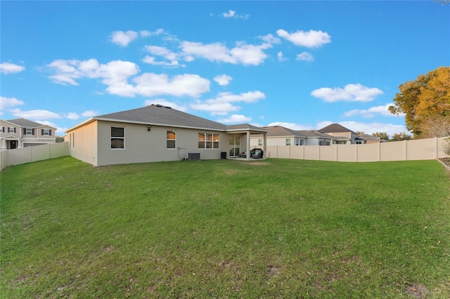 back of house with a yard and central AC