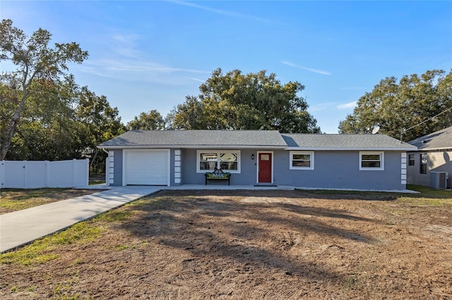 single story home with a porch, a garage, and central AC