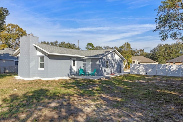 back of property with a yard and a patio