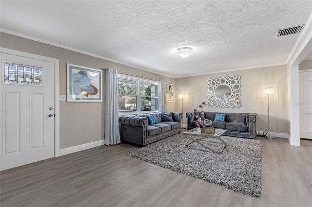 living room featuring ornamental molding, a textured ceiling, and hardwood / wood-style flooring