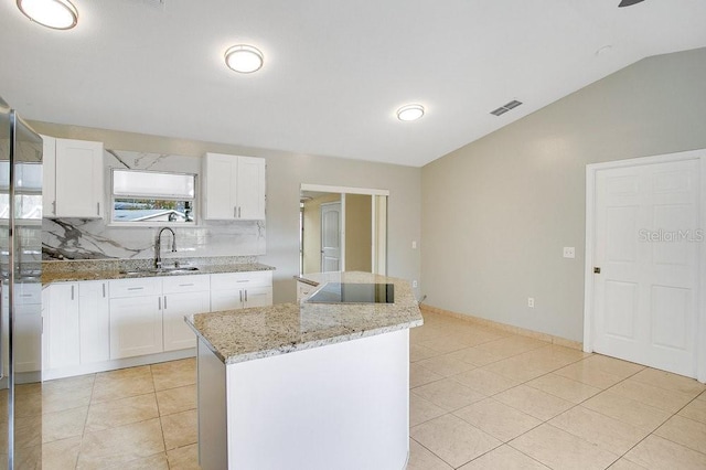 kitchen with white cabinets, sink, and a kitchen island