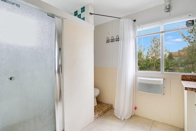 bathroom with tile patterned flooring, a shower with curtain, and toilet