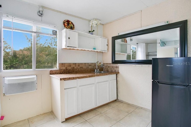 kitchen with white cabinetry, sink, backsplash, refrigerator, and light tile patterned floors