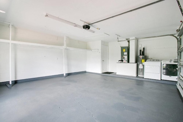 garage featuring electric water heater, separate washer and dryer, and a garage door opener