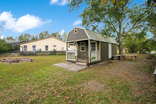 view of outdoor structure featuring a fire pit and a yard