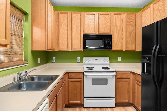 kitchen with sink, black appliances, a textured ceiling, and light hardwood / wood-style floors