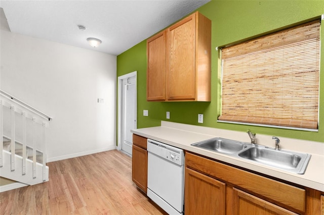 kitchen featuring dishwasher, light wood-type flooring, and sink