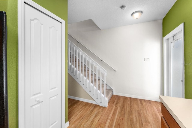 staircase featuring hardwood / wood-style flooring and a textured ceiling