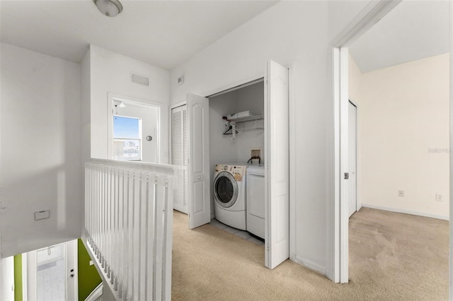 clothes washing area featuring light carpet and washing machine and dryer