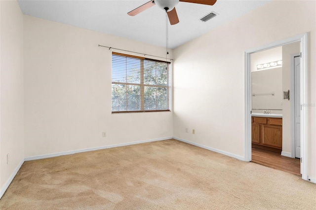 unfurnished bedroom featuring connected bathroom, ceiling fan, sink, and light carpet