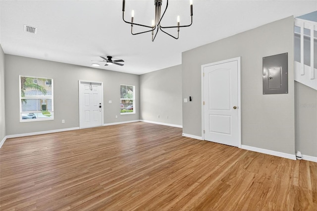13228 Daniels Landing Cir, Winter Garden, FL 34787 - unfurnished living room featuring electric panel, light wood-type flooring, a chandelier, and ceiling fan