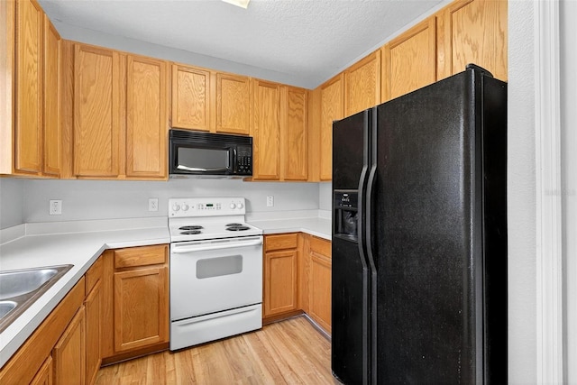13228 Daniels Landing Cir, Winter Garden, FL 34787 - kitchen featuring black appliances, light wood-style flooring, light countertops, and a textured ceiling