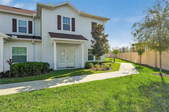 view of front of home with a front yard and french doors