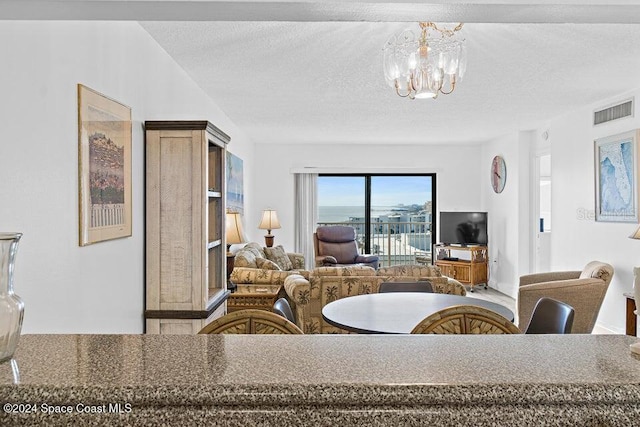 dining area featuring a textured ceiling and a notable chandelier