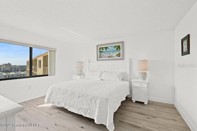 bedroom featuring a textured ceiling and light wood-type flooring