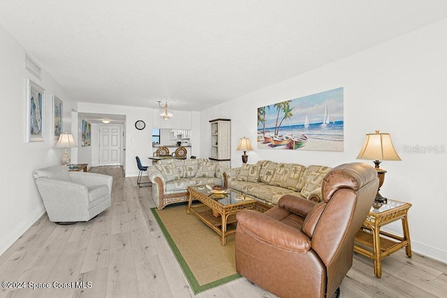 living room featuring light hardwood / wood-style flooring and an inviting chandelier