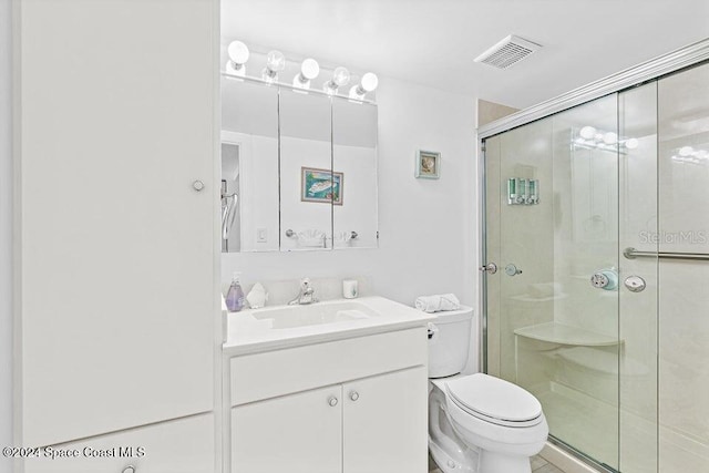 bathroom with vanity, toilet, and a shower with shower door