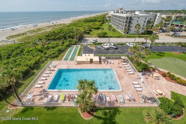 birds eye view of property with a water view and a beach view