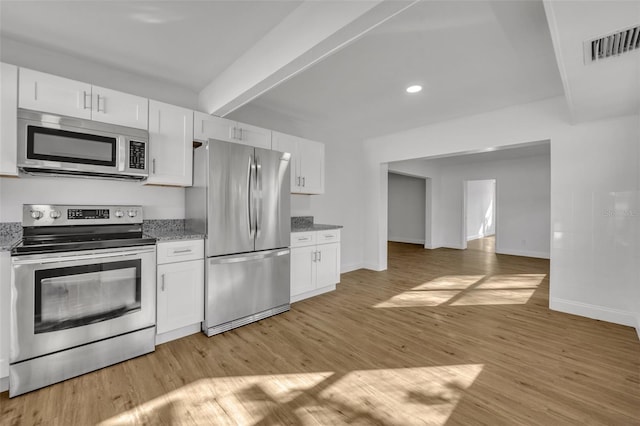 kitchen with white cabinets, stainless steel appliances, light hardwood / wood-style flooring, and stone counters