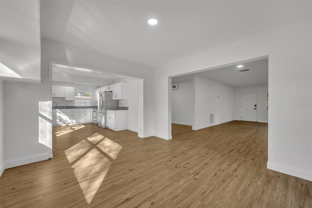 990 Sunrise Dr, Tarpon Springs, FL 34689 - unfurnished living room with light wood-type flooring, baseboards, and recessed lighting