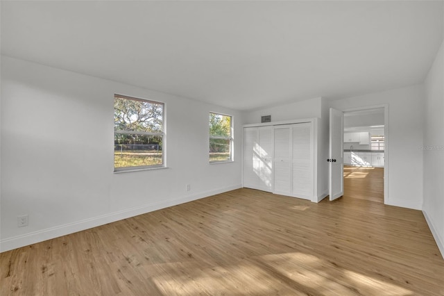 unfurnished bedroom featuring a closet and light wood-type flooring