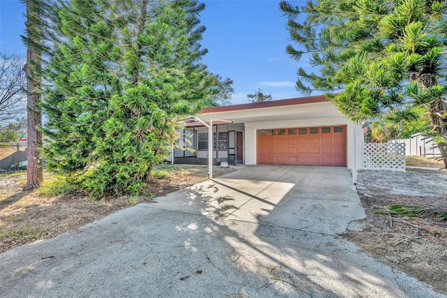 view of front of home with a garage and a sunroom