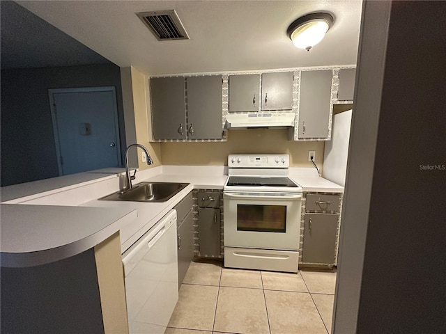 kitchen featuring kitchen peninsula, sink, light tile patterned floors, and white appliances