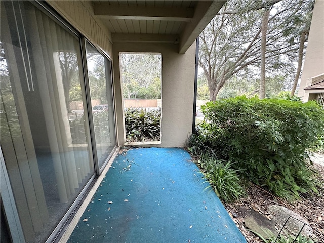 unfurnished sunroom with beam ceiling