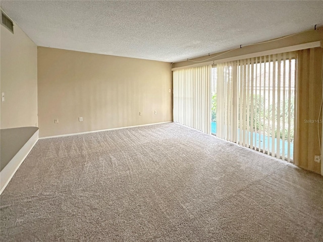 carpeted spare room featuring a textured ceiling