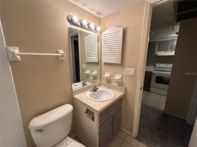 bathroom with tile patterned flooring, a textured ceiling, vanity, and toilet