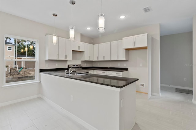 kitchen featuring kitchen peninsula, decorative light fixtures, white cabinetry, and sink