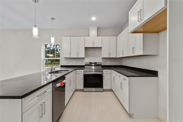 kitchen with pendant lighting, sink, dark stone countertops, appliances with stainless steel finishes, and white cabinetry