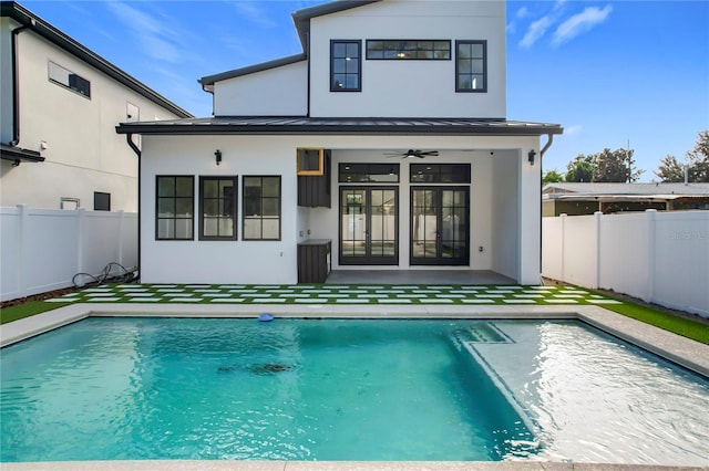 back of property featuring ceiling fan and a fenced in pool