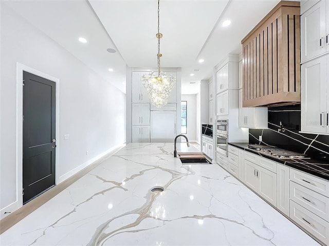 kitchen featuring white cabinets, decorative light fixtures, dark stone counters, sink, and backsplash