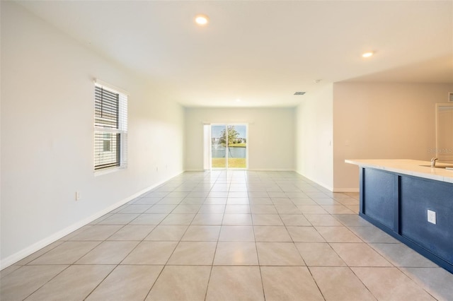 unfurnished room featuring light tile patterned floors and sink