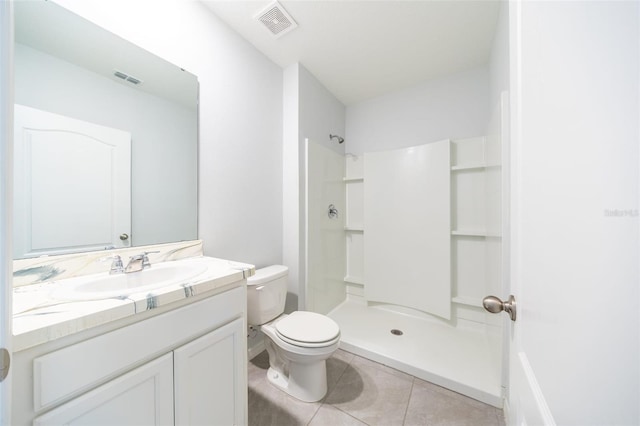 bathroom featuring toilet, tile patterned flooring, vanity, and walk in shower