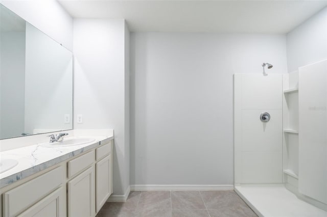 bathroom with a shower, tile patterned flooring, and vanity