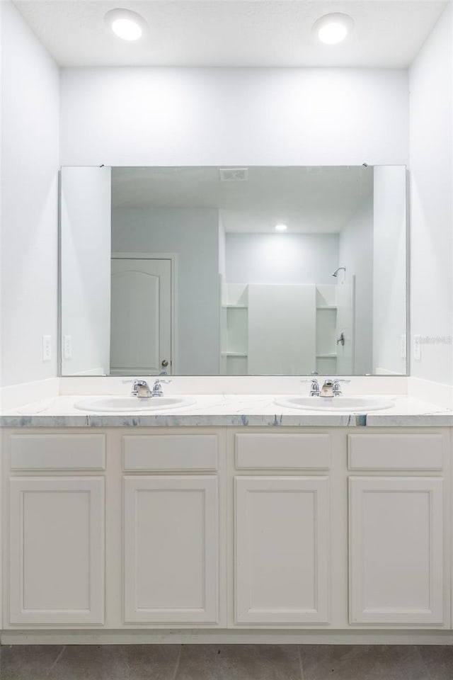 bathroom featuring tile patterned floors, a shower, and vanity