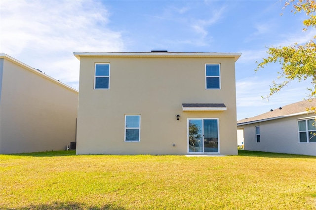 rear view of house featuring a yard and central AC unit