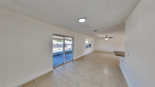 empty room featuring ceiling fan and light tile patterned flooring