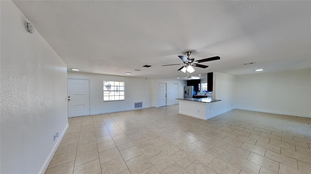 unfurnished living room with light tile patterned floors and ceiling fan