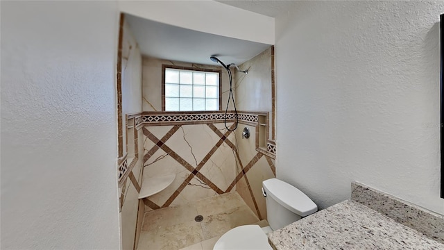 bathroom with toilet and a tile shower