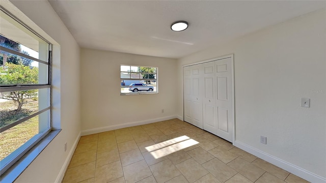 unfurnished bedroom with light tile patterned floors and a closet