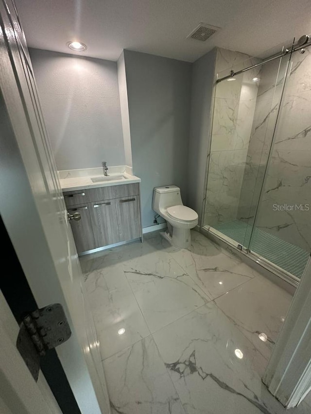 bathroom with vanity, toilet, and a shower with shower door